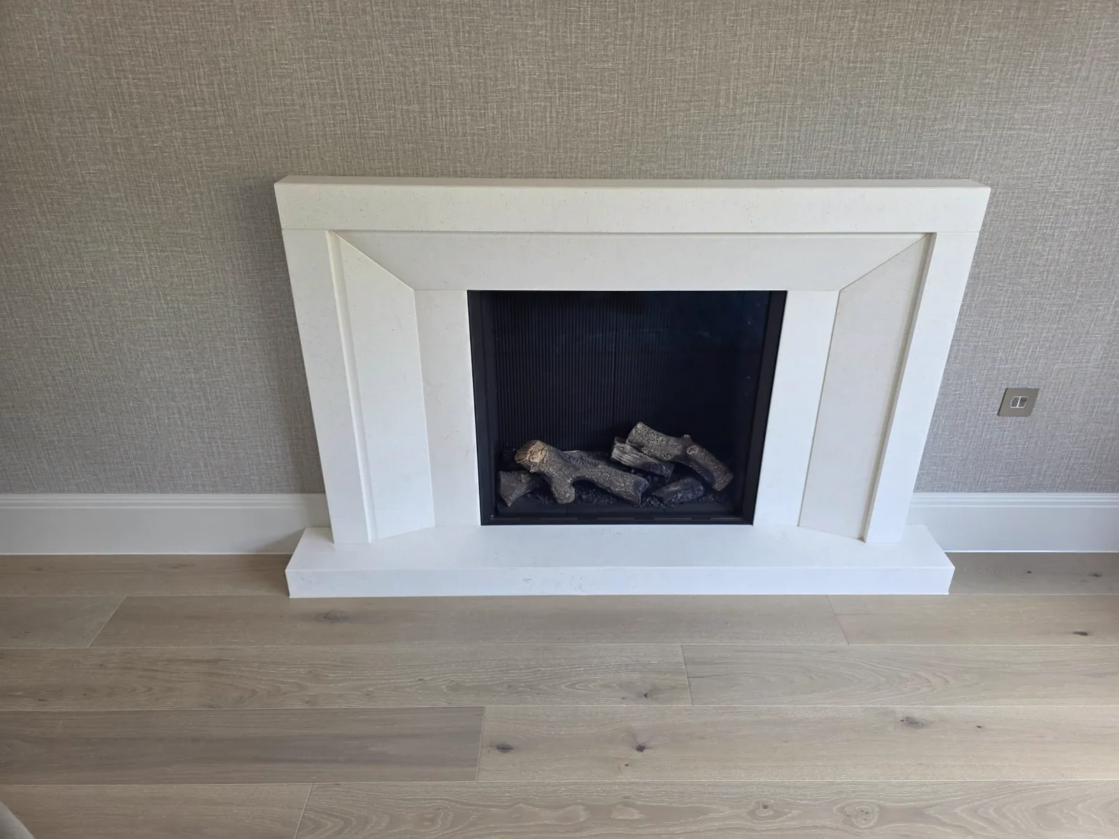 A bespoke Antalya limestone fireplace surround with an inset gas fire in a Henley-in-Arden home