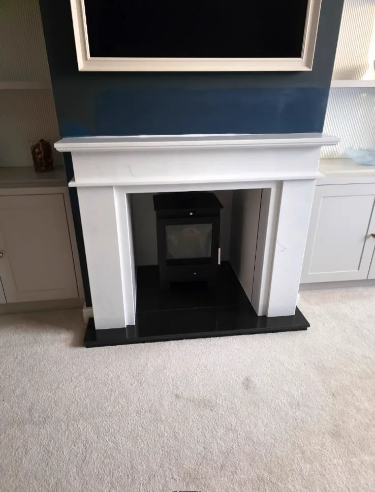 A Rowton marble surround in Arctic Ice with a polished granite stove hearth in a Solihull home