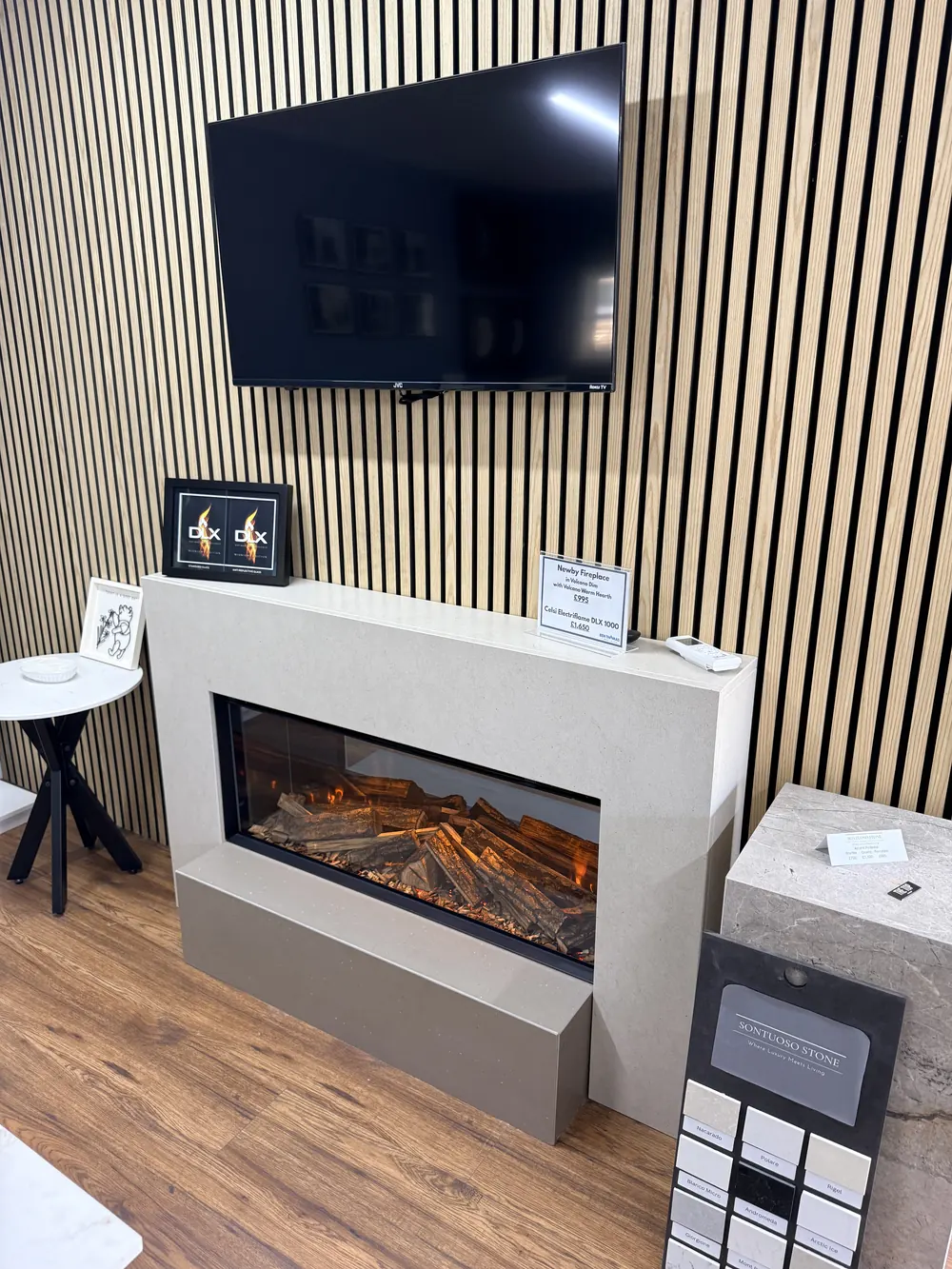 A contemporary media wall display with a wide linear electric fire and slatted timber panelling