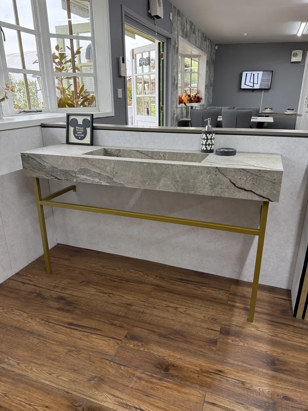 A made-to-measure marble console table with slim brass legs