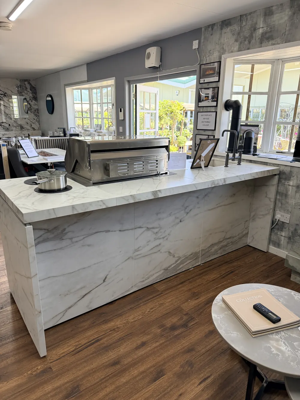A marble worktop and breakfast bar display beside the showroom windows