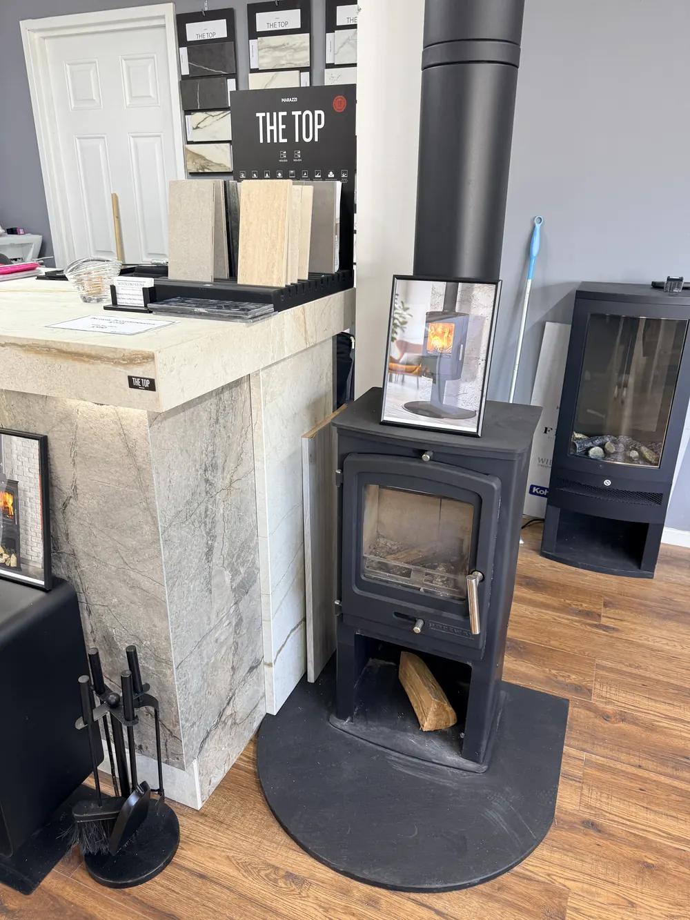 Porcelain samples displayed beside wood burning stoves in the showroom