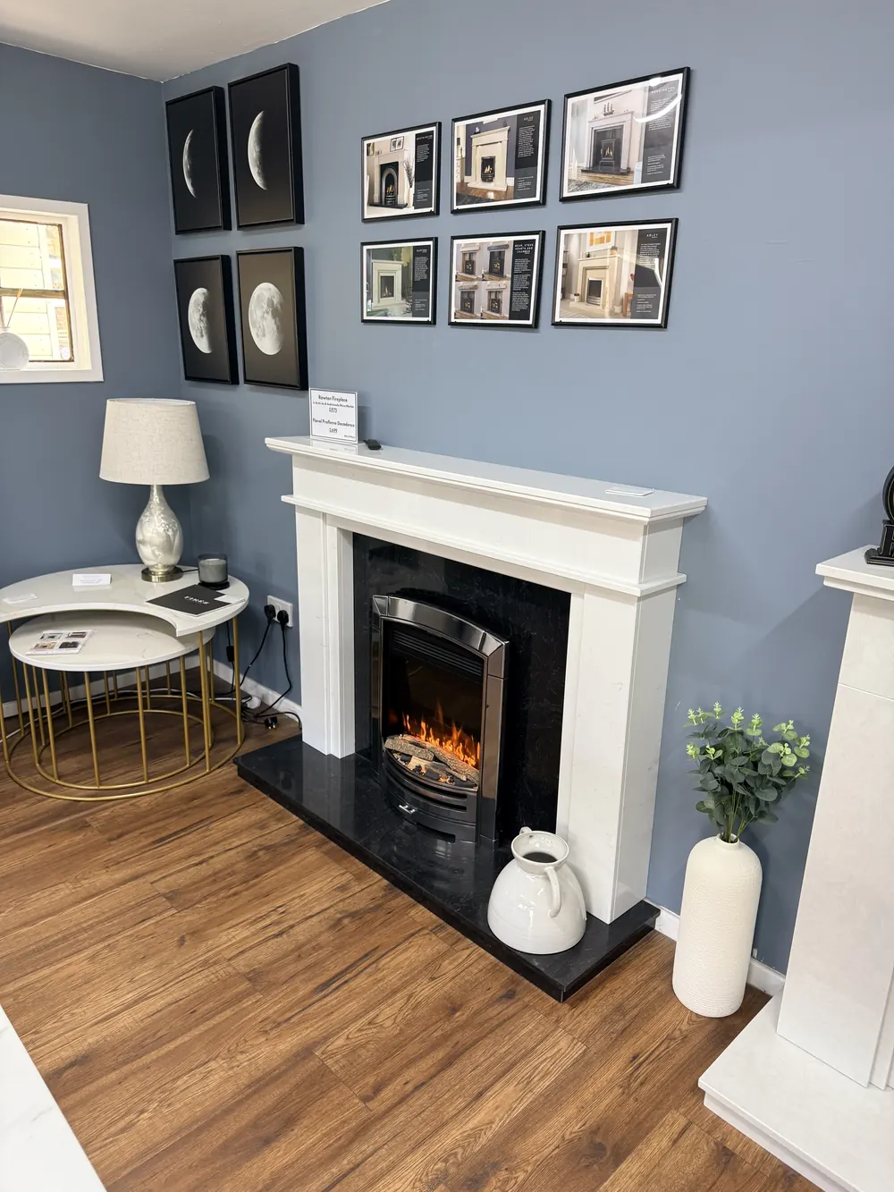 A traditional white marble fireplace surround with a black granite hearth on display
